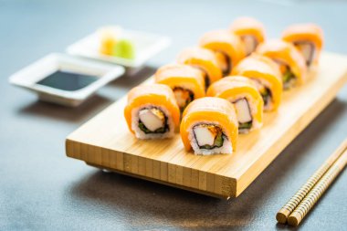 Somon Balık et suşi roll maki wasabi ve soya sosu - Japon yemekleri tarzı ahşap plaka üzerinde