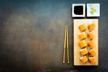 Somon Balık et suşi roll maki wasabi ve soya sosu - Japon yemekleri tarzı ahşap plaka üzerinde