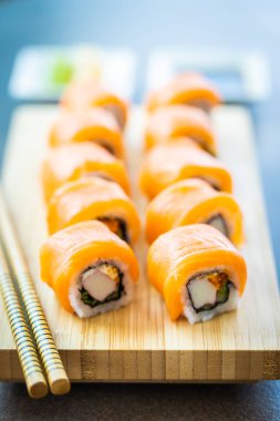 Somon Balık et suşi roll maki wasabi ve soya sosu - Japon yemekleri tarzı ahşap plaka üzerinde