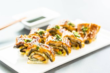 Somon ve beyaz plaka - Japon yemekleri stil üzerinde suşi maki rulo ve tatlı sos içinde sebze ızgara yılan balığı veya unagi balık