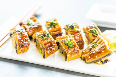 Somon ve beyaz plaka - Japon yemekleri stil üzerinde suşi maki rulo ve tatlı sos içinde sebze ızgara yılan balığı veya unagi balık