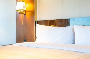 Güzel rahat beyaz yastık yatak yatak odası iç dekorasyonda ışık lamba ile