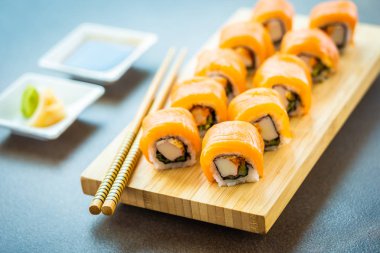 Somon Balık et suşi roll maki wasabi ve soya sosu - Japon yemekleri tarzı ahşap plaka üzerinde