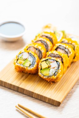 California maki sushi sos ve yemek çubukları - Japon yemekleri tarzı ahşap plaka üzerinde rulo