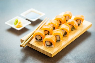 Somon Balık et suşi roll maki wasabi ve soya sosu - Japon yemekleri tarzı ahşap plaka üzerinde