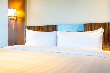 Güzel rahat beyaz yastık yatak yatak odası iç dekorasyonda ışık lamba ile