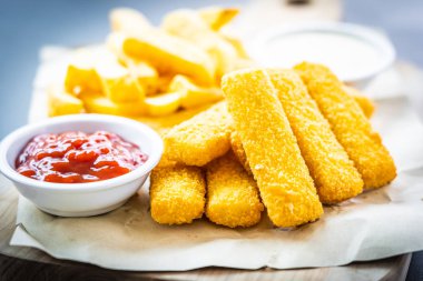 Balık parmak ve patates kızartması veya ahşap kesme tahtası - sağlıksız yiyecek stil üzerinde domates ketçap ve mayonez soslu cips