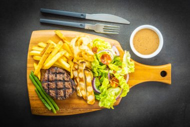 Patates kızartması sosu ve ahşap kesme tahtası üzerinde taze sebze ızgara sığır eti biftek