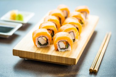 Somon Balık et suşi roll maki wasabi ve soya sosu - Japon yemekleri tarzı ahşap plaka üzerinde