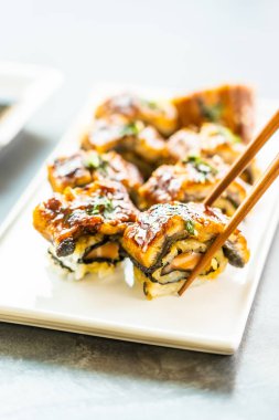 Somon ve beyaz plaka - Japon yemekleri stil üzerinde suşi maki rulo ve tatlı sos içinde sebze ızgara yılan balığı veya unagi balık