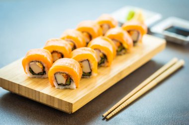 Somon Balık et suşi roll maki wasabi ve soya sosu - Japon yemekleri tarzı ahşap plaka üzerinde