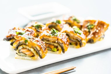 Somon ve beyaz plaka - Japon yemekleri stil üzerinde suşi maki rulo ve tatlı sos içinde sebze ızgara yılan balığı veya unagi balık