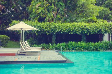 Güzel lüks şemsiye ve sandalye otel ve seyahat ve tatil için tatil yüzme havuzunda çevresinde