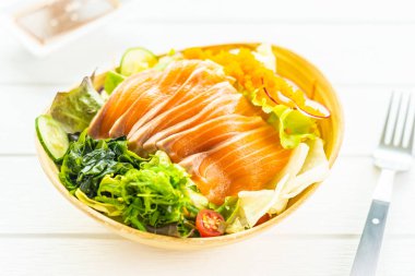 Ham taze somon balık et sashimi sebze salata ve sos - Japonca ve sağlıklı gıda kavramı