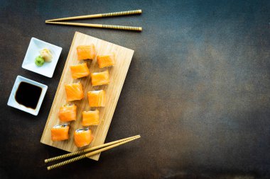 Somon Balık et suşi roll maki wasabi ve soya sosu - Japon yemekleri tarzı ahşap plaka üzerinde