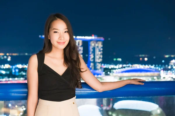 アジアの美しい女性の笑顔とシンガポール市内夜景に満足して — ストック写真