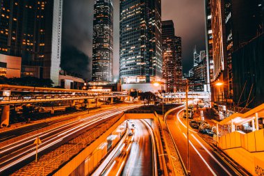 Hong Kong şehrinin dış şehir manzarası geceleri gökyüzüne yükseliyor.