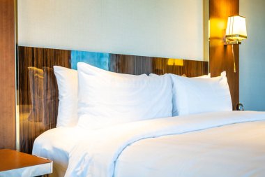 Güzel rahat beyaz yastık yatak yatak odası iç dekorasyonda ışık lamba ile