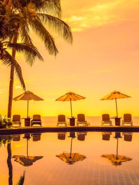 Şemsiye ve sandalye etrafında lüks otel ve resort tatil ve seyahat için açık yüzme havuzu