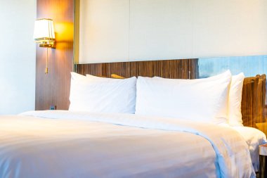 Güzel rahat beyaz yastık yatak yatak odası iç dekorasyonda ışık lamba ile