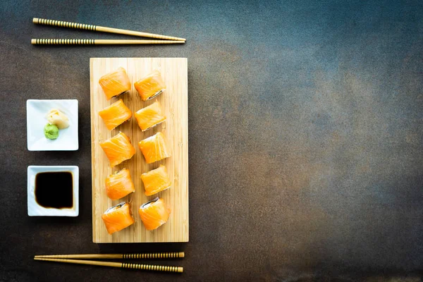サーモンのわさびと醤油 和食スタイル木製プレートに肉寿司ロール巻 — ストック写真