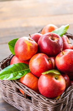 Bir sürü tablo üzerinde kahverengi sepet içinde kırmızı elma meyve