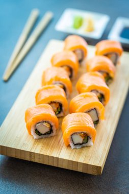 Somon Balık et suşi roll maki wasabi ve soya sosu - Japon yemekleri tarzı ahşap plaka üzerinde