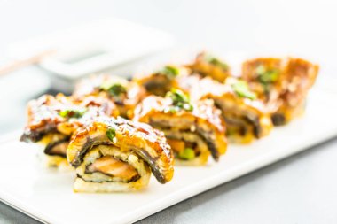 Somon ve beyaz plaka - Japon yemekleri stil üzerinde suşi maki rulo ve tatlı sos içinde sebze ızgara yılan balığı veya unagi balık