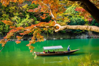 Akçaağaç ağaç yaprak ve sonbahar sezonu Kyoto Japonya göl etrafında tekne ile güzel Arashiyama Nehri