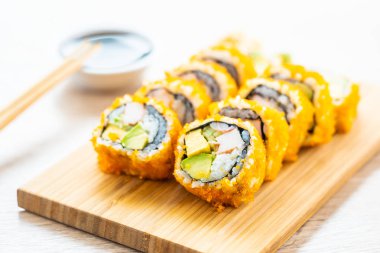 California maki sushi sos ve yemek çubukları - Japon yemekleri tarzı ahşap plaka üzerinde rulo