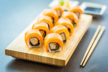 Somon Balık et suşi roll maki wasabi ve soya sosu - Japon yemekleri tarzı ahşap plaka üzerinde