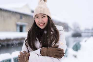 Güzel genç Asyalı kadın gülümseme ve seyahat etmek Otaru kanalında Hokkaido Japonya'da kar ve kış sezonu ile mutlu