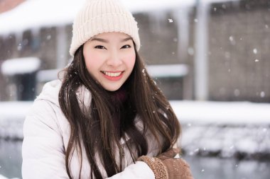 Güzel genç Asyalı kadın gülümseme ve seyahat etmek Otaru kanalında Hokkaido Japonya'da kar ve kış sezonu ile mutlu