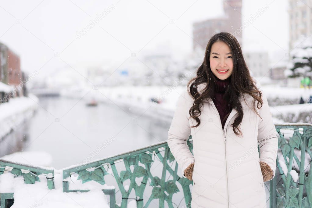 Beautiful young asian woman smile and happy with travel trip at Otaru canal Hokkaido Japan in Snow and Winter Season