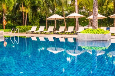 Güzel lüks otel ve tatil seyahat ve tatil için sandalye ve şemsiye ile açık yüzme havuzu