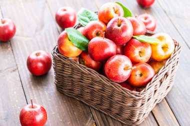 Bir sürü tablo üzerinde kahverengi sepet içinde kırmızı elma meyve