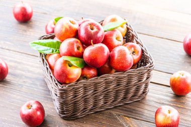 Bir sürü tablo üzerinde kahverengi sepet içinde kırmızı elma meyve