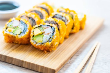 California maki sushi sos ve yemek çubukları - Japon yemekleri tarzı ahşap plaka üzerinde rulo