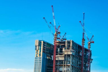 Dış mavi gökyüzü ile bina inşaat alanında vinç