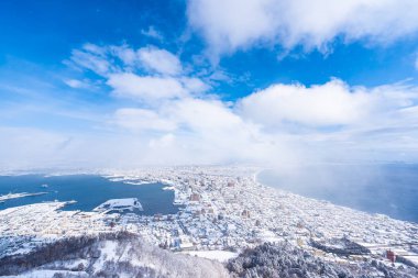 Güzel manzara ve şehir manzarası kurma ve mavi gökyüzü beyaz bulut mimarisiyle etrafa bakmak için gelen dağ Hakodate cityscape