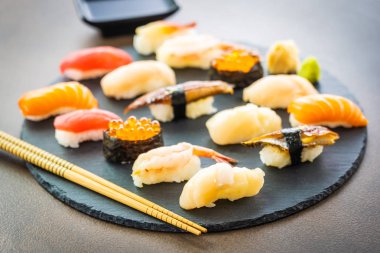 Nigiri suşi somon balıklı karides karides yılan balığı deniz hayvanı kabuğu ve diğer sashimi ile siyah kayrak - Japansese gıda stilini ayarla
