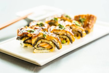 Somon ve beyaz plaka - Japon yemekleri stil üzerinde suşi maki rulo ve tatlı sos içinde sebze ızgara yılan balığı veya unagi balık