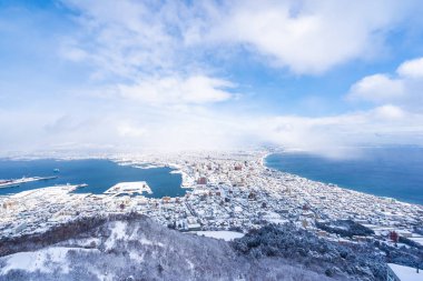 Güzel manzara ve şehir manzarası kurma ve mavi gökyüzü beyaz bulut mimarisiyle etrafa bakmak için gelen dağ Hakodate cityscape