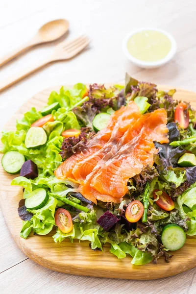 Raw Smoked salmon meat fish with fresh green vegetable salad and sauce - Healthy food concept