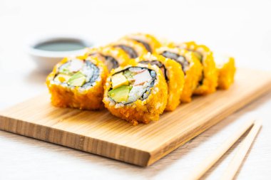 California maki sushi sos ve yemek çubukları - Japon yemekleri tarzı ahşap plaka üzerinde rulo