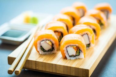 Somon Balık et suşi roll maki wasabi ve soya sosu - Japon yemekleri tarzı ahşap plaka üzerinde