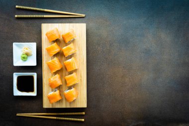 Somon Balık et suşi roll maki ahşap plaka üzerinde