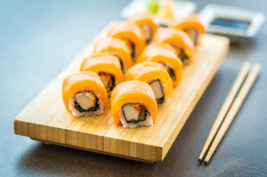 Somon Balık et suşi roll maki ahşap plaka üzerinde