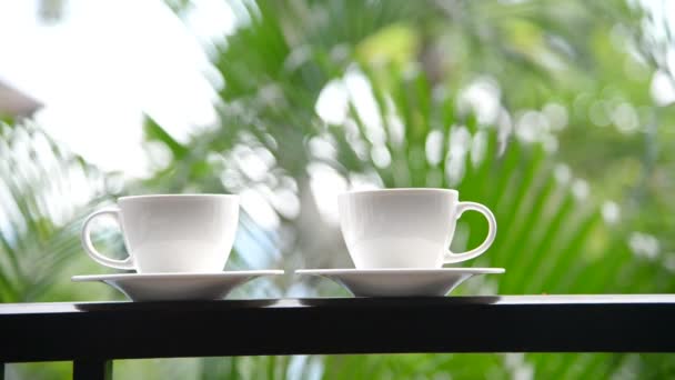 自然の背景の前にバルコニーに立ってコーヒーのカップのクローズアップ映像 — ストック動画