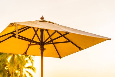 Şemsiye ve şezlong üzerinde güzel plaj ve gündoğumu zaman seyahat ve tatil için deniz